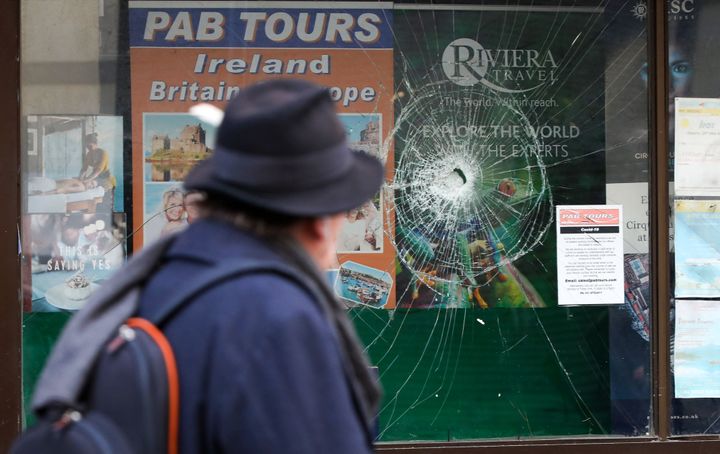 A pedestrian looks at a shop's window, damaged in the November 23 violent protests, near O'Connell Street, in Dublin on November 24, 2023. Rioters who torched vehicles and looted shops in Dublin following a knife attack outside a school brought "shame" on Ireland, Prime Minister Leo Varadkar said on Friday, condemning the worst violence in decades which authorities blamed on right-wing groups. (Photo by PAUL FAITH / AFP) (Photo by PAUL FAITH/AFP via Getty Images)