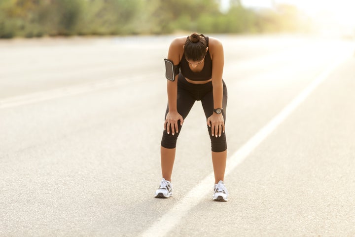 Tired woman runner taking a rest