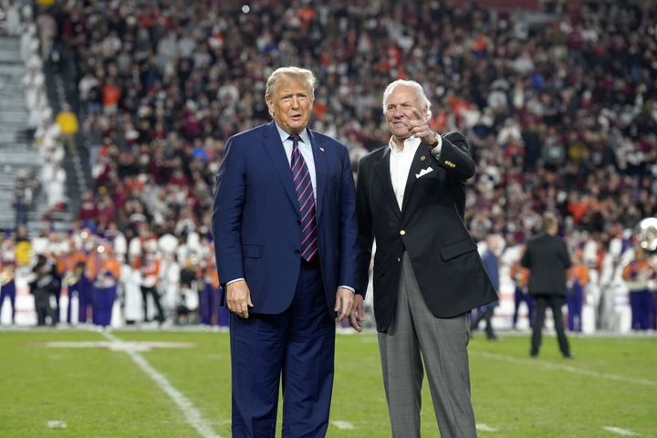 Republican presidential candidate and former President Donald Trump, left, stands with Gov. Henry McMaster, R-S.C., on the field during halftime of an NCAA college football game between the University of South Carolina and Clemson on Saturday, Nov. 25, 2023, in Columbia, S.C. (AP Photo/Meg Kinnard)