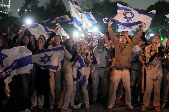 A group of Israelis celebrate as a helicopter carrying hostages released from the Gaza Strip lands at the helipad of the Schneider Children's Medical Center in Petah Tikva, Israel, Sunday Nov. 26, 2023. The cease-fire between Israel and Hamas was back on track Sunday as the militants freed 17 more hostages, including 14 Israelis and the first American, in exchange for 39 Palestinian prisoners in a third set of releases under a four-day truce. (AP Photo/Leo Correa)