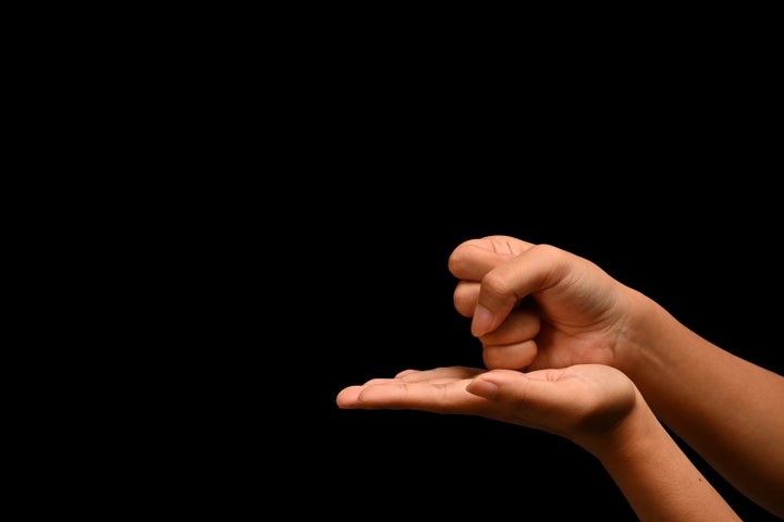 Woman showing sign HELP in American sign language. Sign language is a visual means of communicating using gestures.