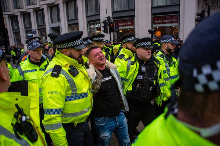 Police officers arrest the far-right English Defence League founder Tommy Robinson outside the Royal Court of Justice in London during the march