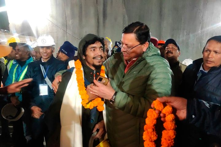 This handout photo provided by the Uttarakhand State Department of Information and Public Relations shows Pushkar Singh Dhami, right, Chief Minister of the state of Uttarakhand, greeting a worker rescued from the site of an under-construction road tunnel that collapsed in Silkyara in the northern Indian state of Uttarakhand, India, on Nov. 28, 2023.
