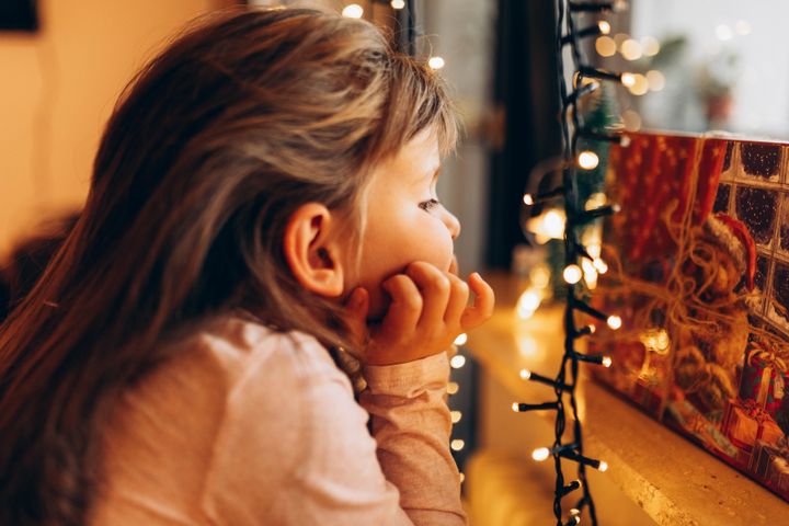 Close-up portrait of a girl waiting to open a Christmas gift.