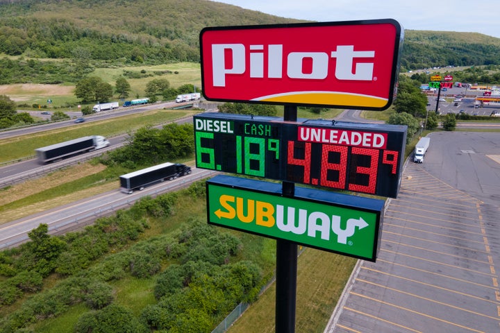 FILE - Trucks and cars drive by a Pilot Travel Center sign displaying fuel prices in Bath, New York, on Monday, June 20, 2022. Warren Buffett’s Berkshire Hathaway says the billionaire Haslam family tried to bribe at least 15 executives at the Pilot truck stop chain with millions of dollars to inflate the company’s profits this year because that would force Berkshire to pay more for the Haslams’ remaining 20% stake in the company. (AP Photo/Ted Shaffrey, File)