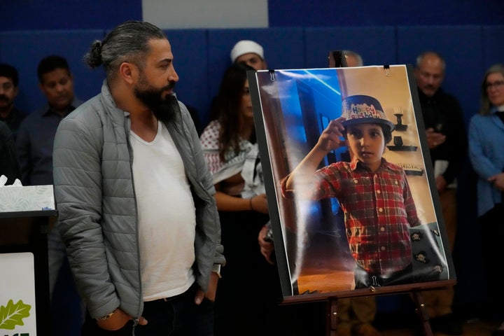 Wadea Al Fayoume's father, Oday Al Fayoume looks at a photo of his sonWadea Al Fayoume during a vigil at Prairie Activity and Recreation center in Plainfield, Ill., late Tuesday, Oct. 17, 2023. An Illinois landlord accused of fatally stabbing the 6-year-old Muslim boy and seriously wounding his mother was charged with a hate crime after police and relatives said he singled out the victims because of their faith and as a response to the war between Israel and Hamas. (AP Photo/Nam Y. Huh)