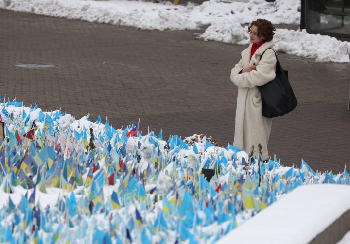 A woman looks at flags bearing symbols and colors of Ukraine that commemorate fallen Ukrainian soldiers at Independence Square in Kyiv on Friday.