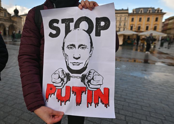 An activist holds a poster with words 'Stop Putin' during a peaceful gathering of members from the local Russian diaspora in Krakow, Poland.