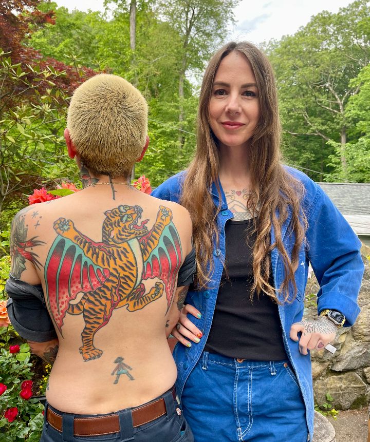 Virginia Elwood (right) with friend and fellow tattooer Tron, who is showing off the tattoo Elwood created for her.