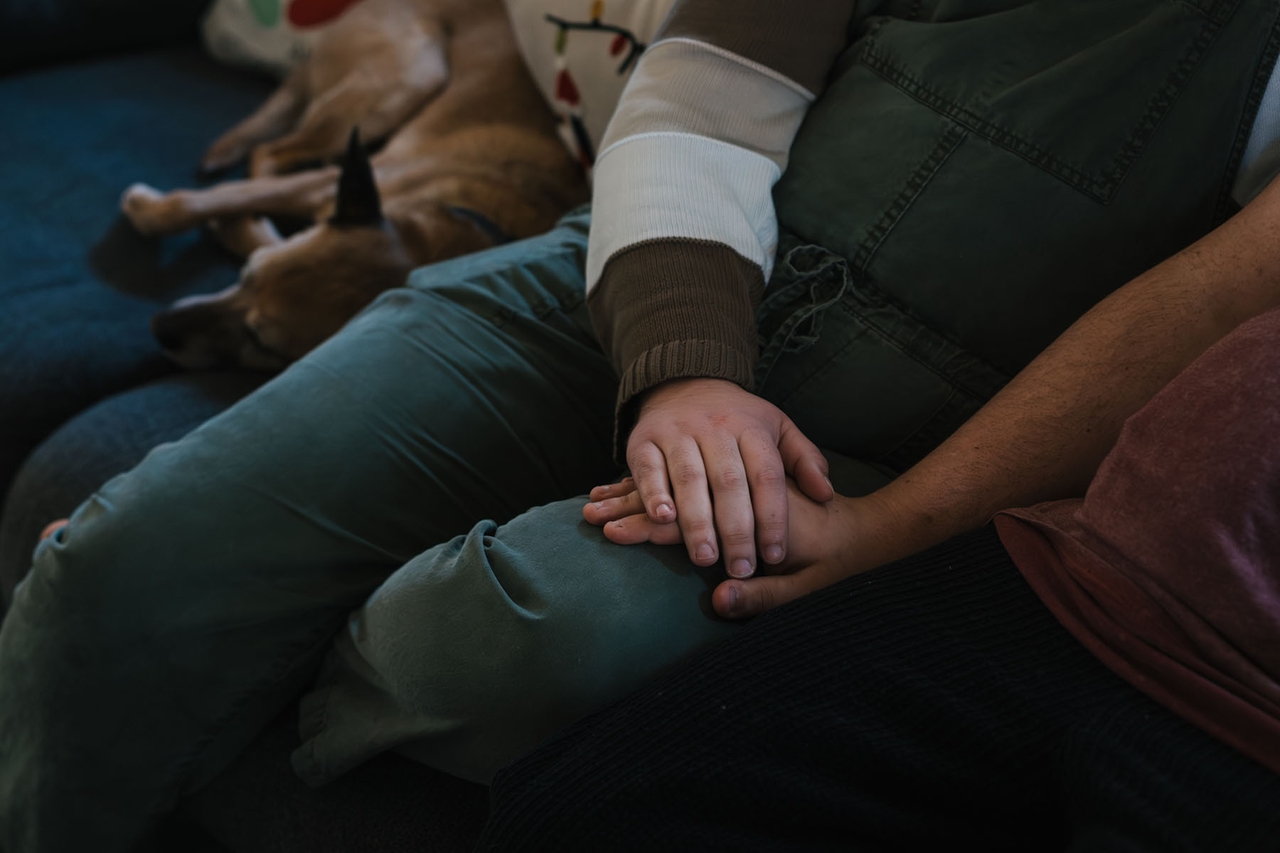 Guido holds his partner’s hand at their home in Wisconsin. Guido struggled after his daughter’s birth, experiencing a brief period of postpartum psychosis followed by depression that lasted for eight months.