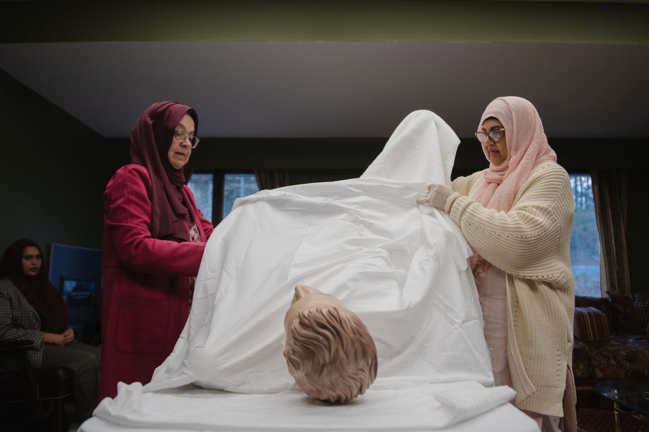 Shaikh, at right, and another woman demonstrate the preparation of a body for burial.