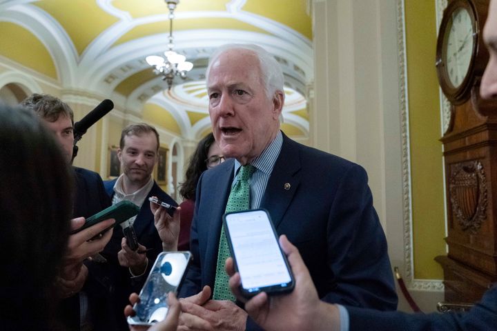 Sen. John Cornyn (R-Texas) speaks to reporters as he walks to the Senate chamber on Wednesday. He said people want to know that aid to Ukraine wouldn't be a blank check.