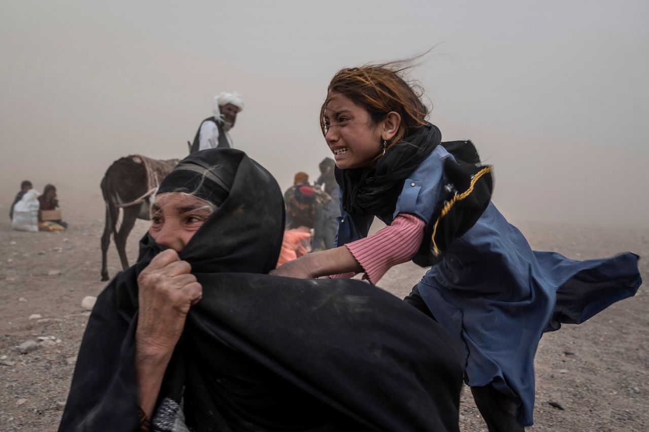 Μικρό κορίτσι στο Αφγανιστάν μαζί με μια γυναίκα, πιθανότατα τη μητέρα της, προσπαθούν να προστατευτούν από μια σαρωτική αμμοθύελλα, η οποία ήρθε αμέσως μετά τους φονικούς σεισμούς με πάνω από 2.000 νεκρούς τον Οκτώβριο.