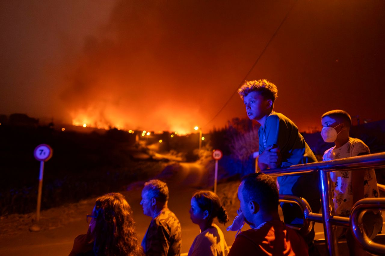 Κάτοικοι κοιτούν με αγωνία τις φλόγες να πλησιάζουν το χωριό τους στην καταστροφική πυρκαγιά της Τενερίφης το περασμένο καλοκαίρι.