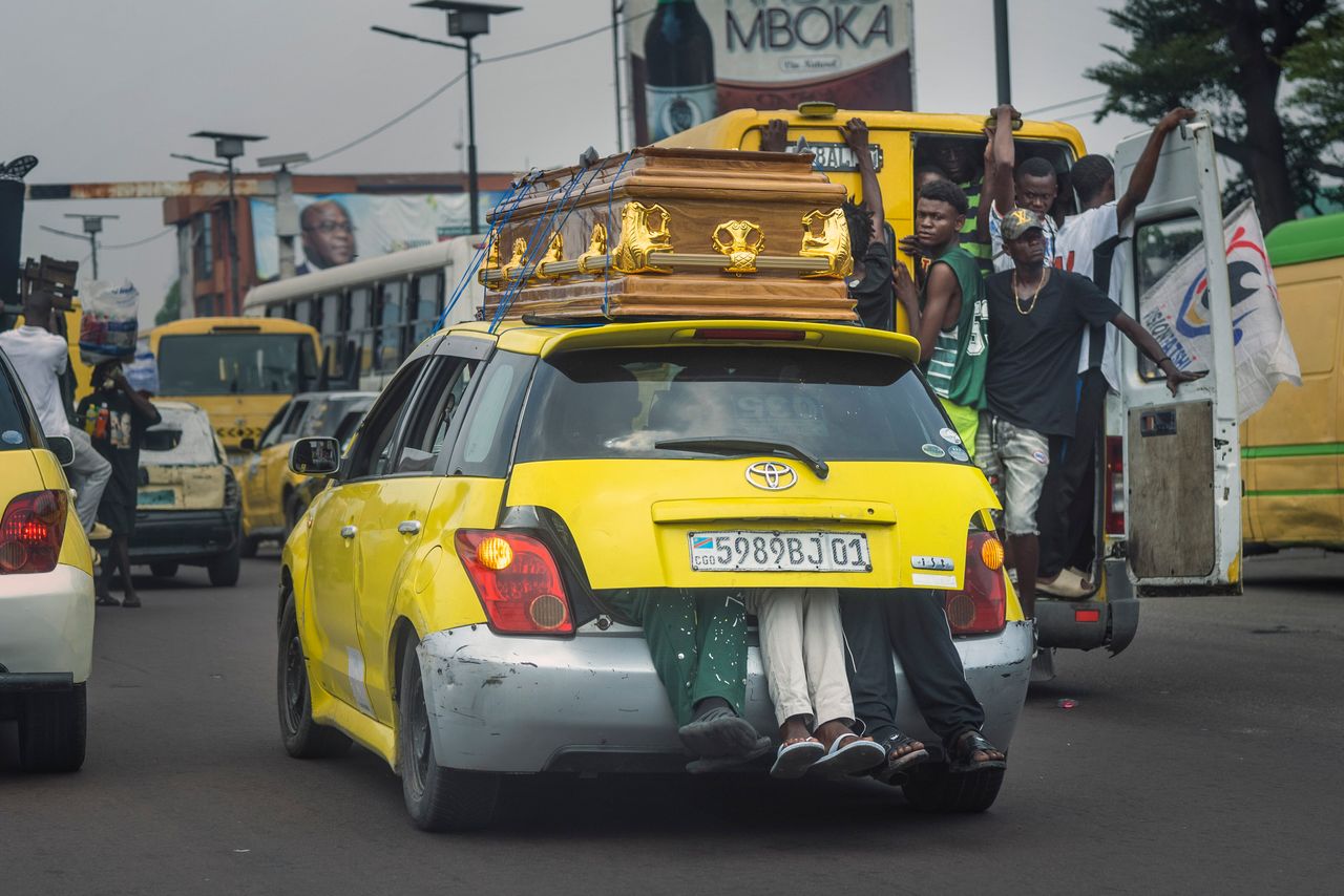 Ταξί με άτομα στο πορτ μπαγκάζ και φέρετρο στην οροφή περιφέρεται στους μποτιλιαρισμένους δρόμους της Κινσάσα του Κονγκό, στον απόηχο της επίσκεψης του Πάπα Φραγκίσκου στη χώρα. 