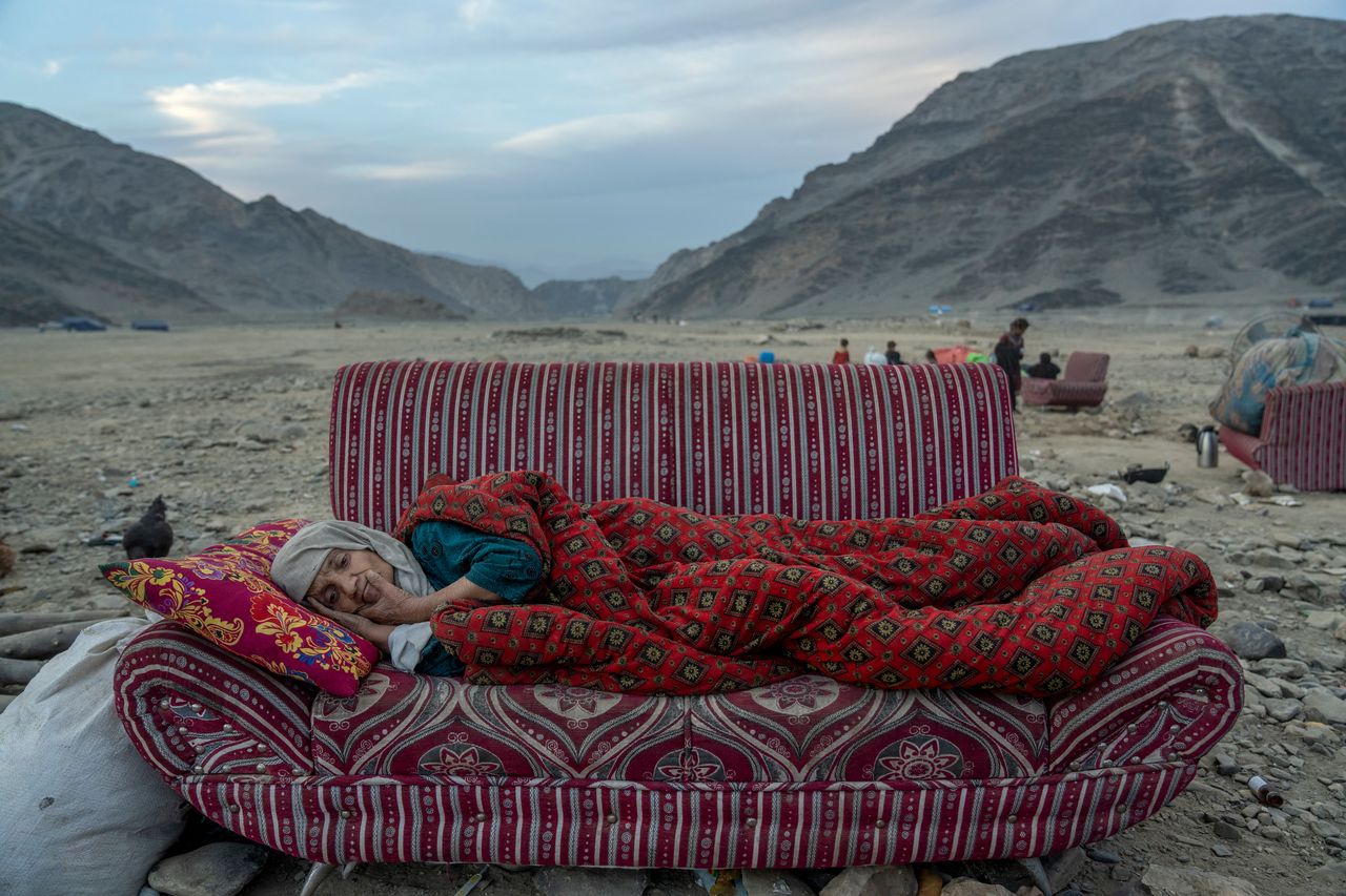 Αφγανή πρόσφυγας ξαπλωμένη σε καναπέ στη μέση της ερήμου, σε καταυλισμό στα σύνορα με το Πακιστάν.