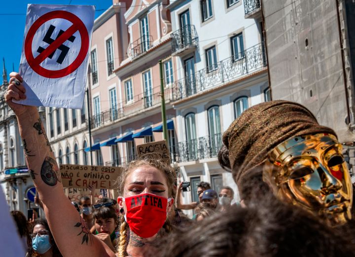 A protester wears a protective mask and holds an anti-Nazi sign during a rally to demonstrate against fascism, Nazism and racism on July 25, 2020, in Lisbon, Portugal.