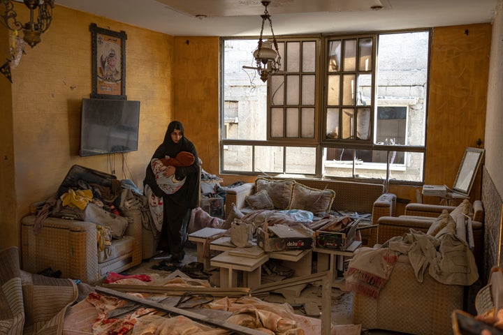 A Palestinian woman holds her child after an Israeli strike on her neighborhood in Rafah, Gaza Strip, on Saturday, Dec. 9, 2023. (AP Photo/Fatima Shbair)