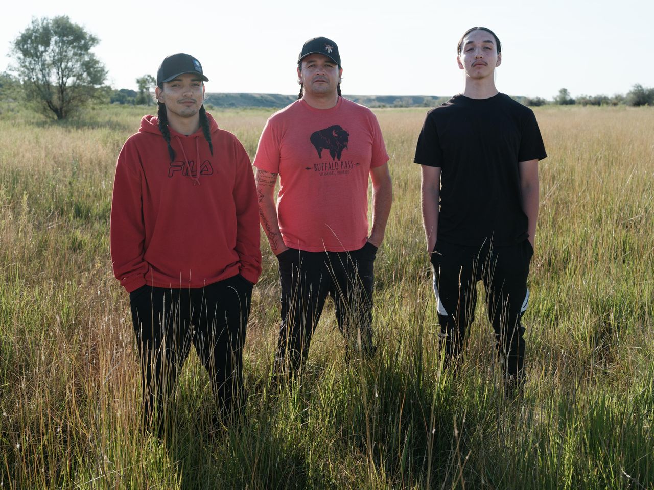 Jason Baldes, center, and his sons Dorian, left, and Kenyan, right, on the land of the Wind River Tribal Buffalo Initiative, Aug. 16, 2023. Baldes founded the Wind River Tribal Buffalo Initiative. His father, Richard Baldes, a biologist and retired U.S. Fish and Wildlife Service project leader, taught him about restoration and conservation. Jason is now passing down that knowledge to his sons.