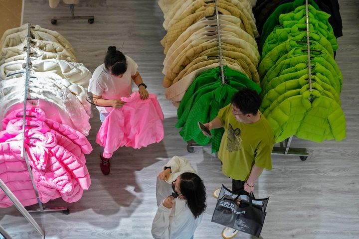 ΑΡΧΕΙΟ - Μια γυναίκα δοκιμάζει ένα φθινοπωρινό ρούχο σε ένα κατάστημα που κάνει μια προσφορά πώλησης ρούχων, σε ένα εμπορικό κέντρο στο Πεκίνο, Κυριακή, 20 Αυγούστου 2023. Η οικονομία της Κίνας παραμένει σε ύφεση, με τις τιμές να πέφτουν λόγω της χαλαρής ζήτησης από καταναλωτές και επιχειρήσεις. (AP Photo/Andy Wong, File)