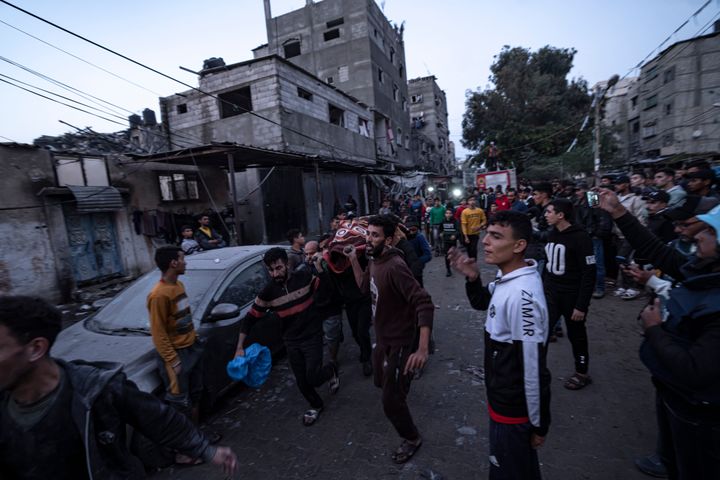 Παλαιστίνιοι μεταφέρουν ένα πτώμα από το σημείο ισραηλινής αεροπορικής επιδρομής, στη Ράφα της Λωρίδας της Γάζας, Τρίτη 12 Δεκεμβρίου 2023.