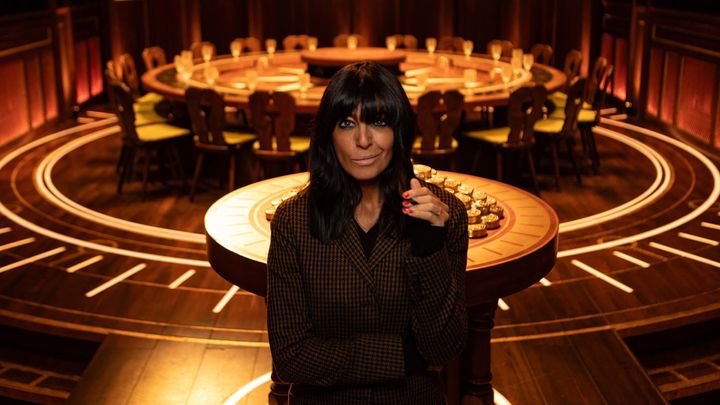 Claudia Winkleman stands before the round table, where players discuss who should be banished