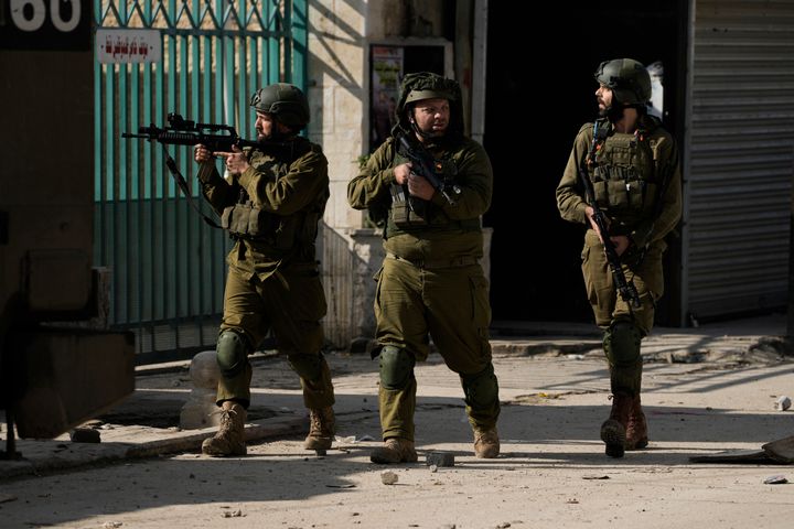Israeli soldiers are seen during an army operation, in the Jenin refugee camp, West Bank, Tuesday, Dec. 12, 2023. Palestinian health officials say four people have been killed in an Israeli strike in the West Bank. (AP Photo/Majdi Mohammed)