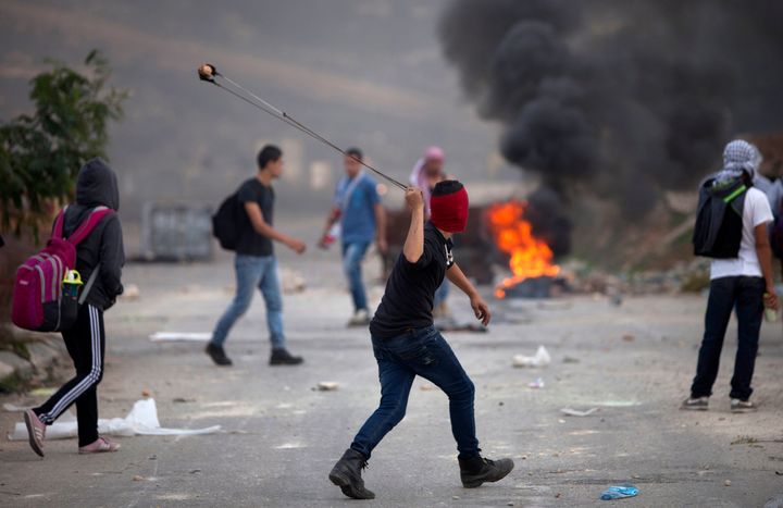 Νεαροί Παλαστίνιοι πετούν πέτρες σε οσραηλινούς στρατιώτες. 