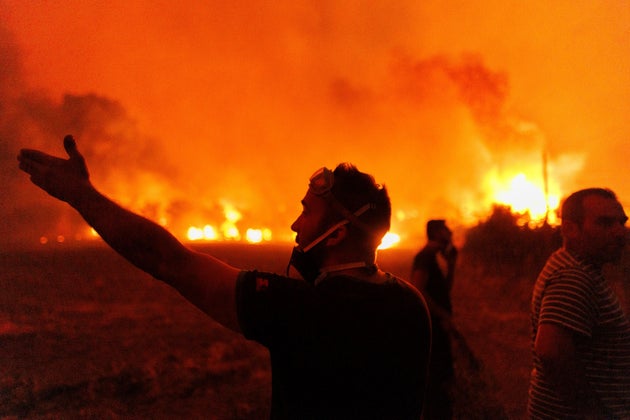People react as they try to extinguish a wildfire in Avantas village, near Alexandroupolis town, in the northeastern Evros region of Greece on Aug. 21, 2023.