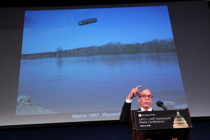 Ufologist Steven Greer delivers remarks in Washington, D.C., in June on his research while standing under a photo of a purported UFO.