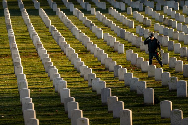 FILE - A man salutes after placing a wreath at Arlington National Cemetery, Saturday, Dec. 16, 2023, in Arlington, Va. (AP Photo/Nathan Howard, File)