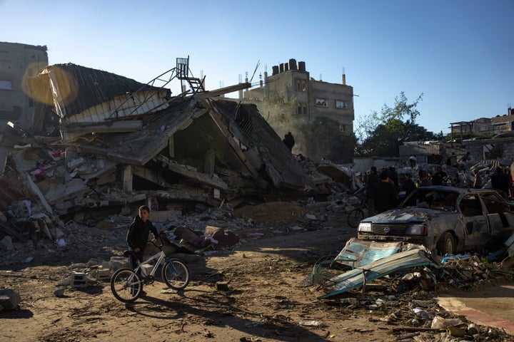 Palestinians search for bodies and survivors in the rubble of a residential building destroyed in an Israeli airstrike, in Rafah, southern Gaza Strip, Friday, Dec. 15, 2023. (AP Photo/Fatima Shbair)