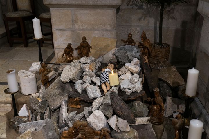 An installation of a scene of the Nativity of Christ with a figure symbolizing baby Jesus lying amid the rubble, in reference to Gaza, inside the Evangelical Lutheran Church in the West Bank town of Bethlehem on Dec. 10. World-famous Christmas celebrations in Bethlehem have been put on hold due to the ongoing Israel-Hamas war.