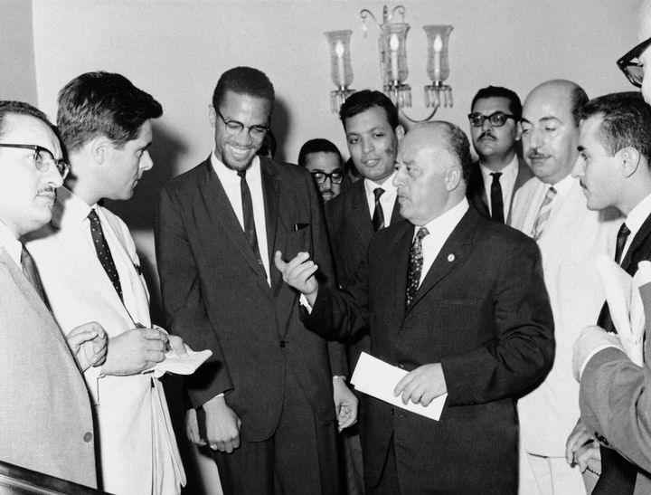 Malcolm X, third from left, is shown with Ahmed Shukairi, center with extended hand, head of the newly formed Palestinian Liberation Organziation, explains at a news conference the significance of each of the four colors on the Palestinian flag in Egypt in Sept. 1964.