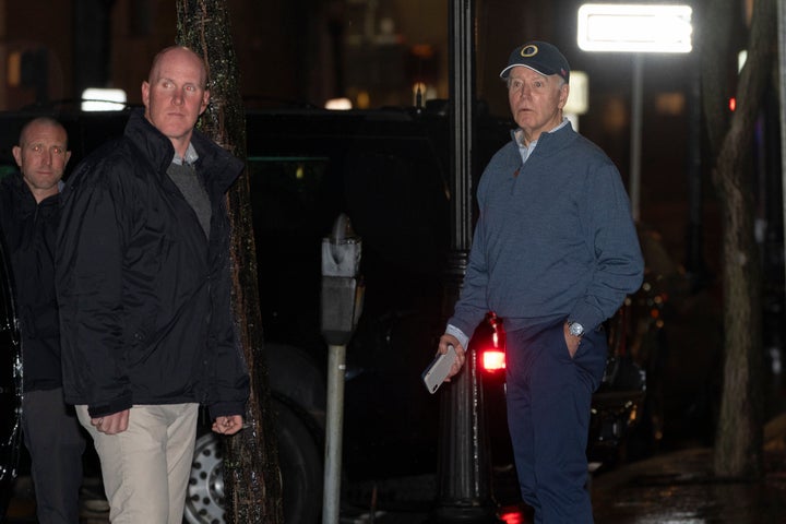 President Joe Biden reacts after hearing a loud bang as he leaves his campaign headquarters in Wilmington on Sunday after a car plowed into a parked SUV that was part of his motorcade.
