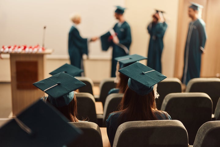 Back view of students attending a graduation ceremony in lecture hall.