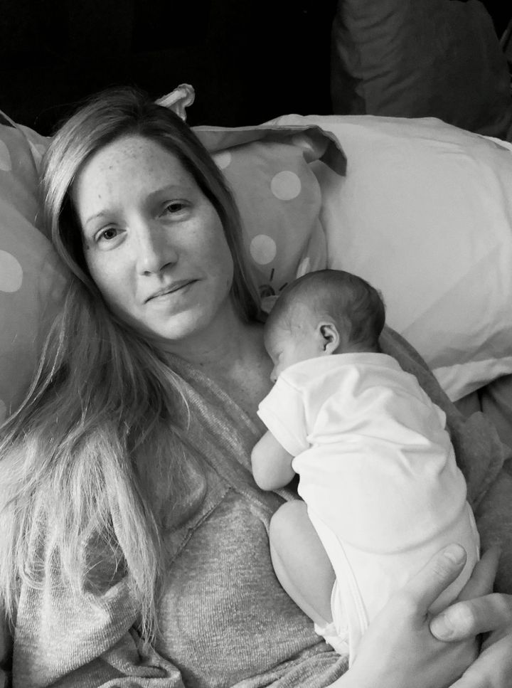 The author holds her 1-week-old son after returning home from the hospital, in the wake of an emergency D&C and postpartum hemorrhage.