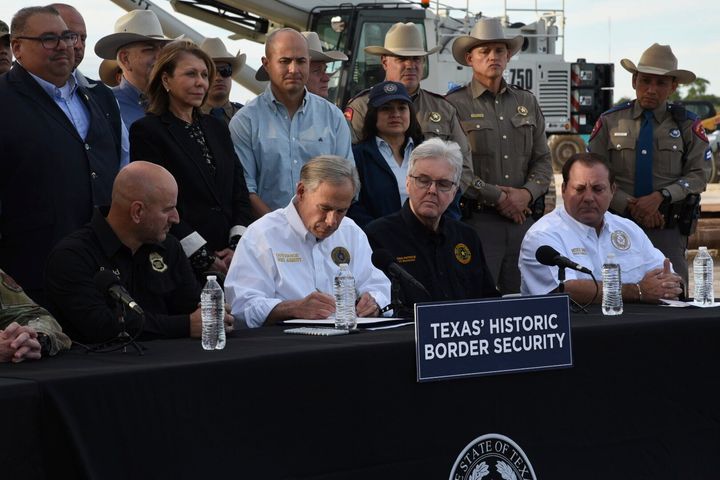 Texas Gov. Greg Abbott (R) signs three bills into law at a border wall construction site in Brownsville, Texas, on Dec. 18.
