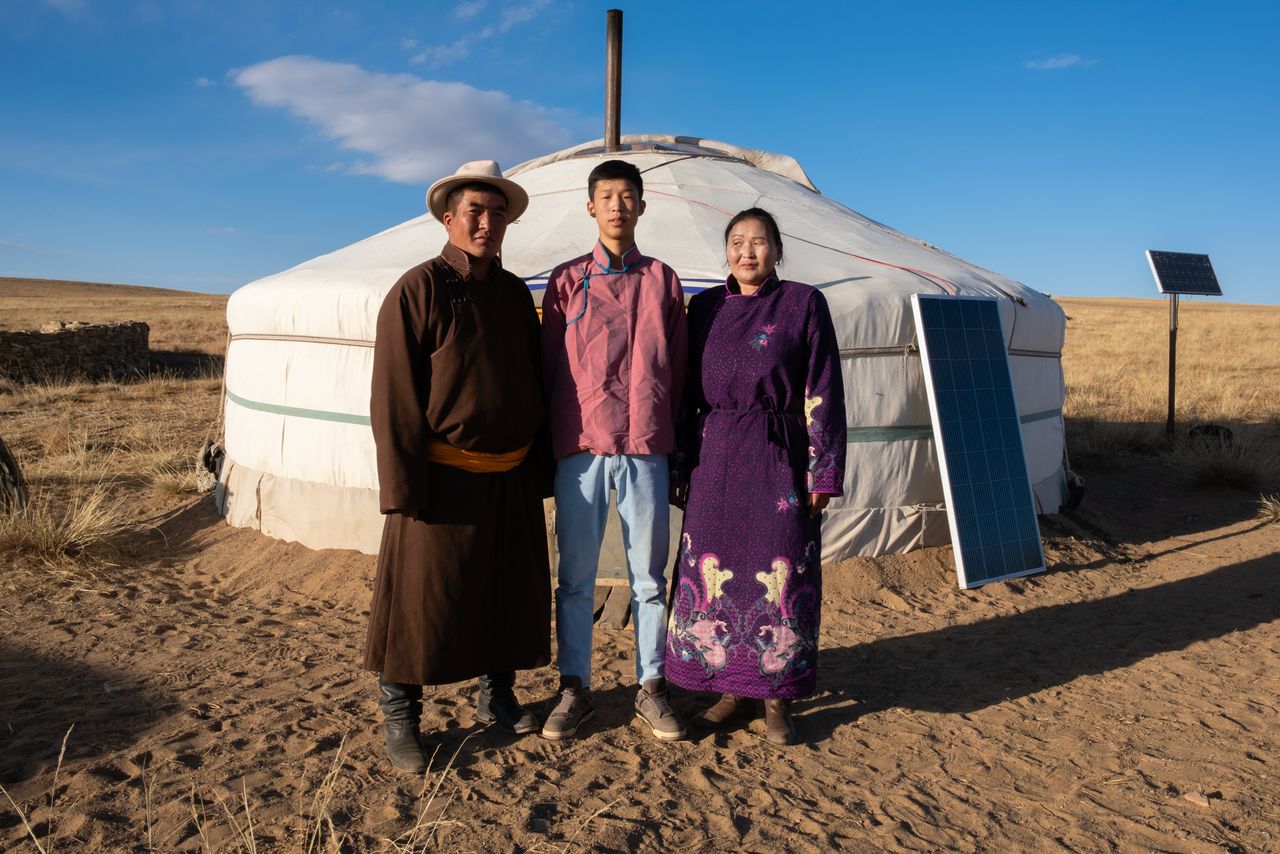 Purev-Erdene Davaadalai, 16, stands between his parents, Davaadalai Gongor, 41, and Batnasana Damdinjav, 40, outside the family's mobile ger tent on the central Mongolian steppe in October.