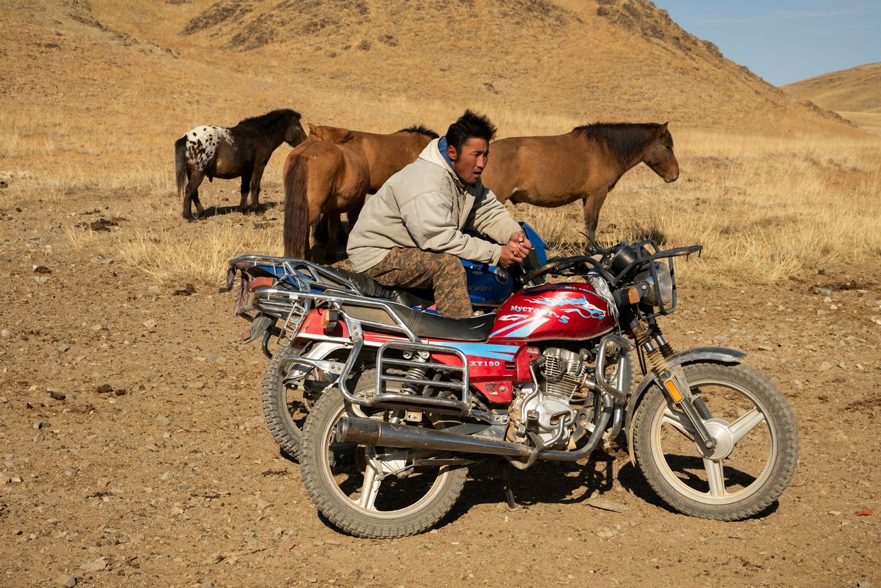 A herder rests on his motorcycle at a well that locals in this part of central Mongolia attached to a trough for livestock.