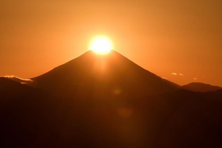 The sun is setting at the peak of Mt. Fuji around the day of the winter solstice.