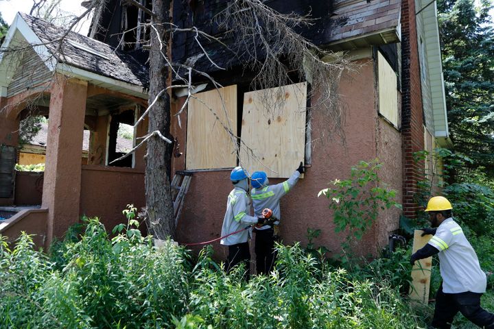 FILE - In this June 11, 2019 file photo, members of the Detroit's Board Up Brigade board up a vacant home in north Detroit. Serial killer DeAngelo Martin lured women one by one into vacant homes to be murdered. (AP Photo/Carlos Osorio, File)