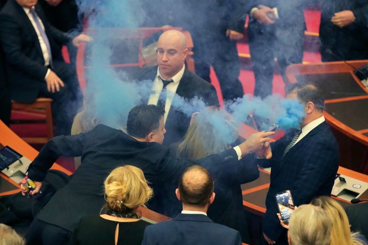 Ο Φλαμούρ Νόκα, νομοθέτης του Δημοκρατικού Κόμματος, στρέφει μια φωτοβολίδα καπνού στο πρόσωπο ενός φύλακα κατά τη διάρκεια συνεδρίασης του κοινοβουλίου στα Τίρανα της Αλβανίας, Πέμπτη 21 Δεκεμβρίου 2023.