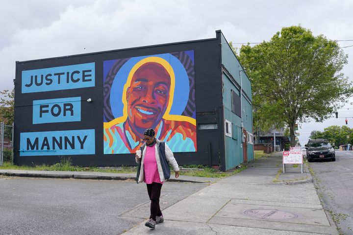 FILE - A woman walks past a mural honoring Manuel "Manny" Ellis, on May 27, 2021, in the Hilltop neighborhood of Tacoma, Wash. Ellis died March 3, 2020, after he was restrained by police officers. Jury selection begins Monday, Sept. 18, 2023, in the trial of the three Tacoma police officers charged in his death. (AP Photo/Ted S. Warren, File)