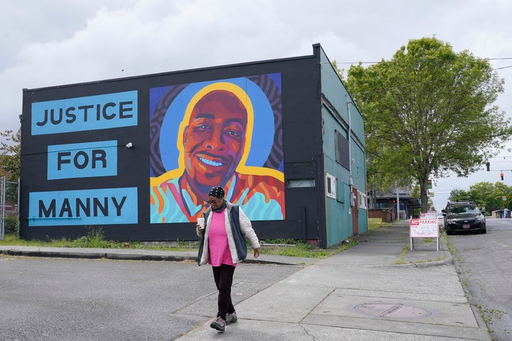 FILE - A woman walks past a mural honoring Manuel "Manny" Ellis, on May 27, 2021, in the Hilltop neighborhood of Tacoma, Wash. Ellis died March 3, 2020, after he was restrained by police officers. Jury selection begins Monday, Sept. 18, 2023, in the trial of the three Tacoma police officers charged in his death. (AP Photo/Ted S. Warren, File)