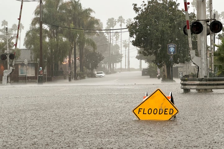 A flooded streets is shown in front of train tracks as rain comes down on Dec. 21, 2023, in Santa Barbara, Calif.