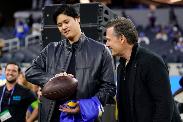 Los Angeles Dodgers' Shohei Ohtani attends an NFL football game between the Los Angeles Rams and the New Orleans Saints with his agents Nez Balelo, right, Thursday, Dec. 21, 2023, in Inglewood, Calif. (AP Photo/Ryan Sun)