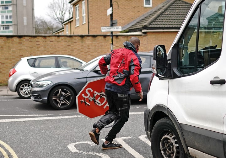 An individual gets rid of an art piece work by Banksy, which reveals what appears like 3 drones on a traffic stop indication, which was revealed at the crossway of Southampton Way and Commercial Way in Peckham, south east London. Image date: Friday December 22, 2023. (Photo by Aaron Chown/PA Images through Getty Images)