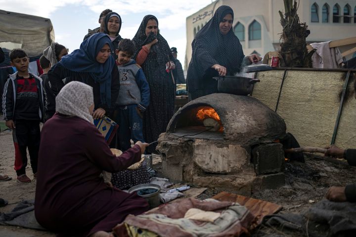 Γυναίκες στη περιοχή Μαουάσι, όπου έχουν καταφύγει πολλοί εκτοπισμένοι κάτοικοι της βόρειας Γάζας, ψήχουν ψωμί
