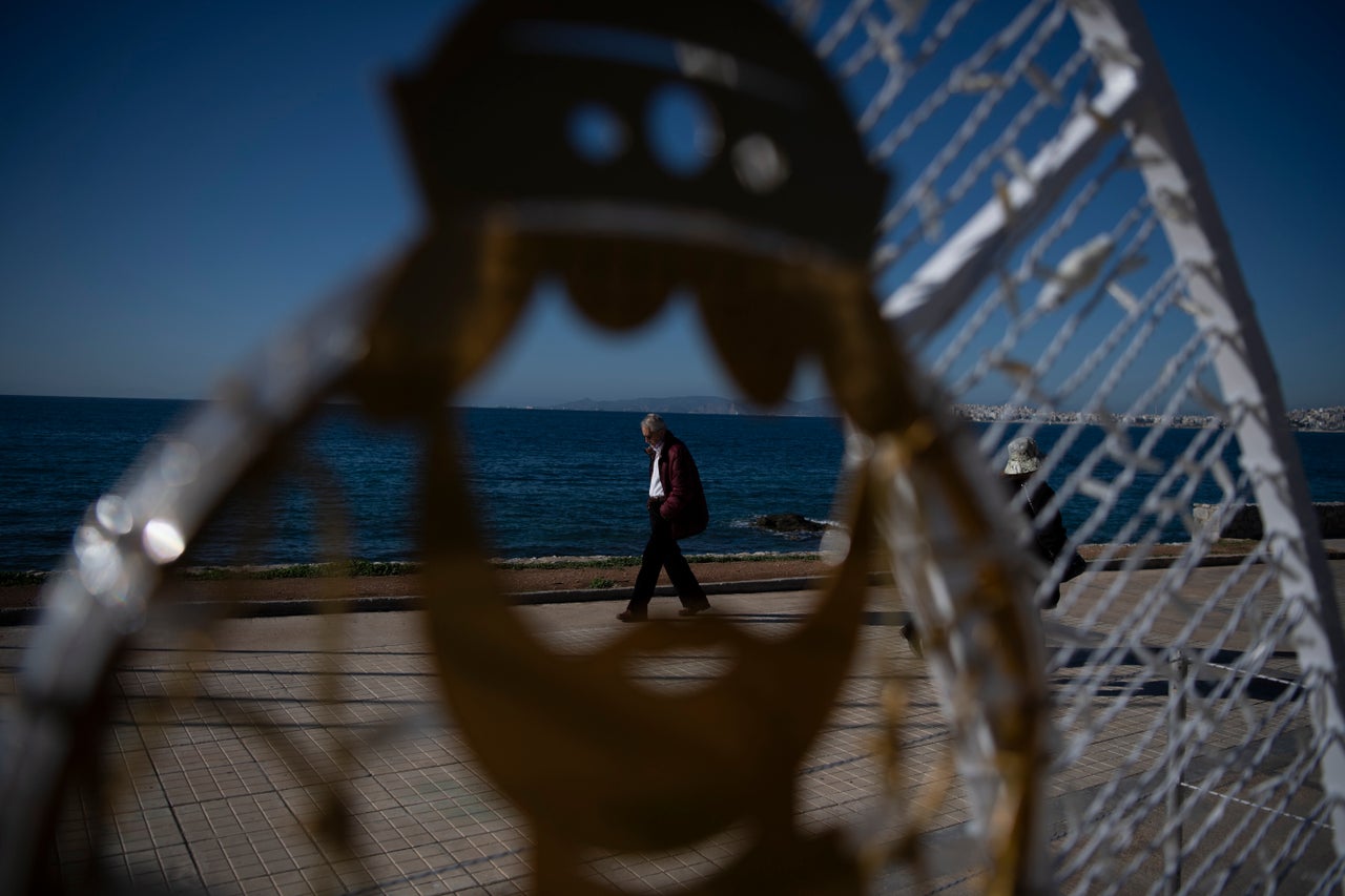 Ανδρας απολαμβάνει τη βόλτα του στη χριστουγεννιάτικη λιακάδα του Παλαιού Φαλήρου.